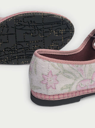 The Camellia Block Mary Jane by FLABELUS is a handmade pink and white floral shoe with a buckle strap, shown on a white background. This Spanish design combines charming details with comfort.