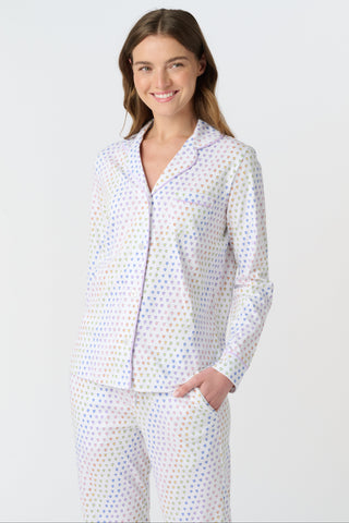 The Infant Disco Hearts Zipper Footie features white Pima cotton fabric with small, colorful, hand-drawn rainbow hearts evenly spaced across it. The soft material has a slightly wrinkled appearance.