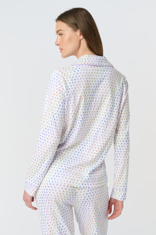 The Infant Disco Hearts Zipper Footie features white Pima cotton fabric with small, colorful, hand-drawn rainbow hearts evenly spaced across it. The soft material has a slightly wrinkled appearance.