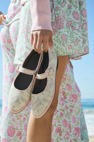 The Camellia Block Mary Jane by FLABELUS is a handmade pink and white floral shoe with a buckle strap, shown on a white background. This Spanish design combines charming details with comfort.