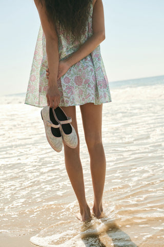 The Camellia Block Mary Jane by FLABELUS is a handmade pink and white floral shoe with a buckle strap, shown on a white background. This Spanish design combines charming details with comfort.