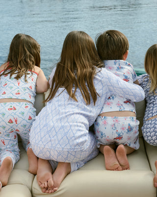 Five children in matching pajamas sitting on a boat.