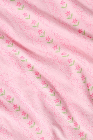 The Kids Daisy Heart Stripe Lucy Pants by Roller Rabbit are crafted from soft Pima cotton genie pant fabric in rose pink, featuring an elastic waistband and cuffs, with a subtle striped pattern and small floral designs throughout—making them a charming addition to girls' fashion.