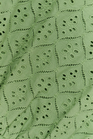 A woman wearing the Roller Rabbit Elsa Eyelet Nicole Top in sage green cotton, featuring an eyelet pattern and ruffled shoulder straps, shown from the shoulders to the waist against a plain background.