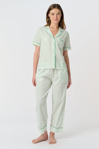 Close-up of the white cambric cotton Hearts Liza Set, featuring a pattern of small green hearts from the Disco Hearts print. The fabric’s texture and soft folds are visible.