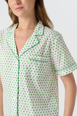 Close-up of the white cambric cotton Hearts Liza Set, featuring a pattern of small green hearts from the Disco Hearts print. The fabric’s texture and soft folds are visible.