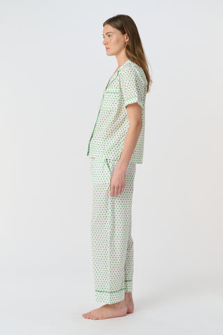 Close-up of the white cambric cotton Hearts Liza Set, featuring a pattern of small green hearts from the Disco Hearts print. The fabric’s texture and soft folds are visible.
