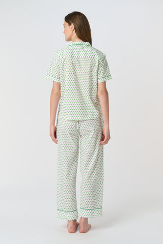 Close-up of the white cambric cotton Hearts Liza Set, featuring a pattern of small green hearts from the Disco Hearts print. The fabric’s texture and soft folds are visible.