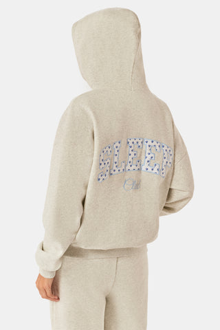 A person with long blonde hair wears the Roller Rabbit Sleep Club Lola Hoodie and wide leg sweatpants in light gray Dream Fleece, standing with hands in the hoodie pockets against a plain white background.