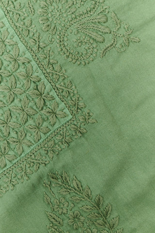 A woman wearing the Roller Rabbit Faith Top—a light green, short-sleeve embroidered cotton blouse with a split neckline—paired with white pants, stands against a plain light background.