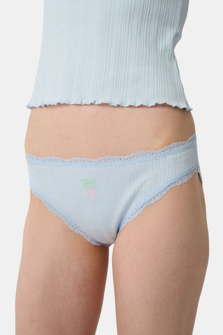 The Roller Rabbit Fruits Embroidery Bikini 4 Pack features four ribbed girls' panties—two pink, two light blue—made from soft Pima cotton with delicate lace trim and playful embroidered fruits for a retro touch.