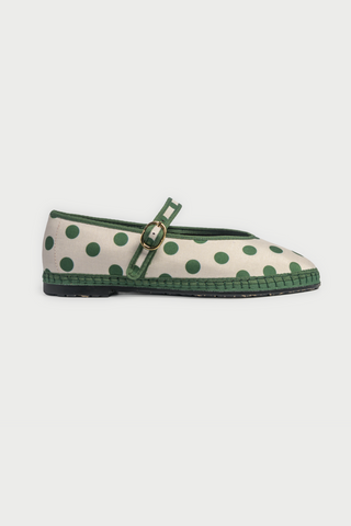 The FLABELUS Polka Dot Pierre is a cream Mary Jane flat with green trim, a green strap featuring a gold buckle, and polka dots—part of the Flabelus collaboration.