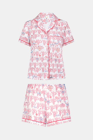 Introducing the Roller Rabbit Gamma Phi Beta Monkey Polo Pajamas: a short-sleeve Pima cotton set featuring a button-up top and matching shorts, adorned with a whimsical pink and blue monkey pattern and red trim on a crisp white background.