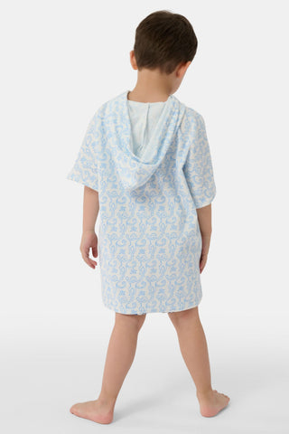 A young child smiles at the camera while wearing the Roller Rabbit Kids Monkey Jesse Cover Up, a light blue and white terry zip-up onesie with a playful animal pattern, against a plain background.