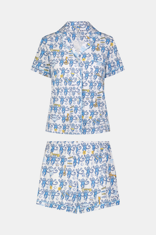 The Roller Rabbit Kappa Kappa Gamma Monkey Polo Pajamas feature a short-sleeve button-up pajama shirt with a front button placket and matching shorts with an elastic waistband, adorned with a playful blue monkey and yellow motif on a white background. Crafted from soft Pima cotton for extra comfort.
