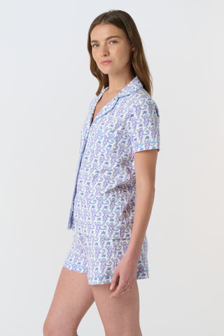 A close-up of Monkey Polo Pajamas made from pima cotton, featuring playful blue and pink monkeys holding branches on a white background—a cozy choice for a polo-style pajama set.