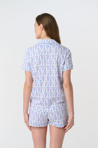 A close-up of Monkey Polo Pajamas made from pima cotton, featuring playful blue and pink monkeys holding branches on a white background—a cozy choice for a polo-style pajama set.