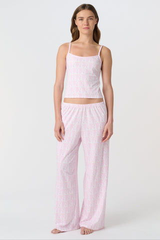 A person stands barefoot on a white background, wearing the Roller Rabbit Lovely Monkey Monroe Pant, light pink loungewear PJ pants with a subtle pattern. The image is cropped above the waist.