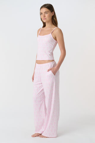 A person stands barefoot on a white background, wearing the Roller Rabbit Lovely Monkey Monroe Pant, light pink loungewear PJ pants with a subtle pattern. The image is cropped above the waist.