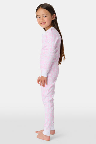 A child stands barefoot, smiling in Kids Lovely Monkey Pajamas with a playful monkey print and a buttoned neckline, set against a plain white background.