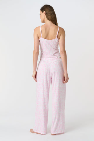 A person stands barefoot on a white background, wearing the Roller Rabbit Lovely Monkey Monroe Pant, light pink loungewear PJ pants with a subtle pattern. The image is cropped above the waist.
