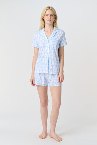 Lovely Monkey Polo Pajamas feature a light blue cartoon monkey pattern with heart-shaped tails and small blue hearts on a white background, adding cheerful charm and whimsy to any Pima cotton pajamas collection—perfect for weddings.