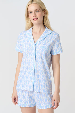 Lovely Monkey Polo Pajamas feature a light blue cartoon monkey pattern with heart-shaped tails and small blue hearts on a white background, adding cheerful charm and whimsy to any Pima cotton pajamas collection—perfect for weddings.