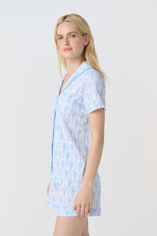 Lovely Monkey Polo Pajamas feature a light blue cartoon monkey pattern with heart-shaped tails and small blue hearts on a white background, adding cheerful charm and whimsy to any Pima cotton pajamas collection—perfect for weddings.