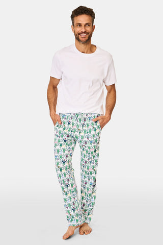 A smiling man stands barefoot in Mens Boston Monkey Simon Pant pajama bottoms and a plain white T-shirt, hands in his pockets, against a white background—perfect for cozy nights in Boston.
