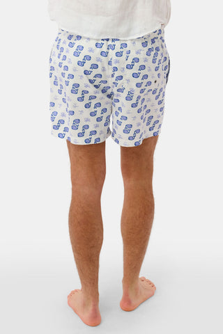 A barefoot person, seen from behind, wears the Mens Moby Swim Trunk—white with a blue sunglass print and mesh lining—against a plain white background.