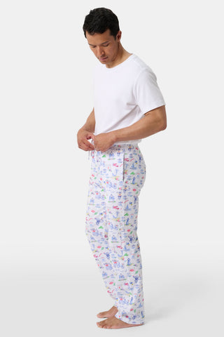 Crafted from soft Pima cotton, the Roller Rabbit Monkey On The Vineyard Long Sleeve Polo Pajamas feature a button-up long-sleeve top and long pants adorned with the playful Monkey on the Vineyard print, showcasing various animals, objects, and buildings on a plain white background.