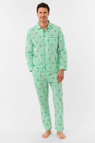 A man stands barefoot against a white background, smiling and facing forward, wearing Roller Rabbit's Mens Leo Gingham Loungewear—a light green, long-sleeved button-up set with matching pants featuring a small lion print pattern.