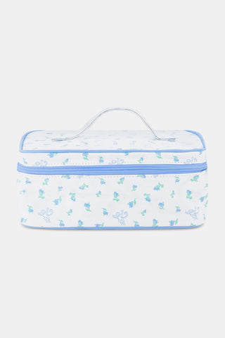 The Roller Rabbit Mini Monkey Blossom Carry All Case is a rectangular white fabric toiletry bag featuring a blue floral and monkey pattern, blue trim, a zip-around top closure, and a clear plastic handle on the lid.
