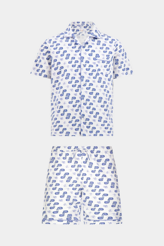A man stands barefoot facing forward in Roller Rabbit’s Mens Moby Louie Pajamas—a Pima cotton set with blue patterns on white, featuring a short-sleeve button-up shirt and shorts—against a plain white background.