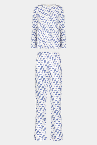 A woman with long blonde hair wears the Roller Rabbit Moby Pajamas, featuring a blue and white repeating print, as she stands barefoot against a plain white background.