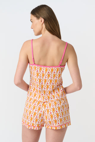 A close-up of fabric from the Monkey Mischa Set, showing a playful pattern with orange cartoon monkeys with curly tails and pink butterflies on a white background.