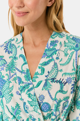 A woman models the Roller Rabbit Amanda Kimono, a knee-length, light blue and white floral cambric cotton robe with wide sleeves and a matching belt, standing against a plain white background.