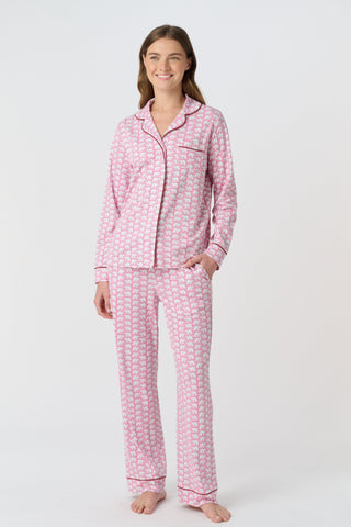 The Hathi Polo Pajamas feature white elephants outlined in red on a pink background, arranged in diagonal rows. Each stylized elephant has a red dot for an eye. Inspired by the Hathi print and made in Peru.