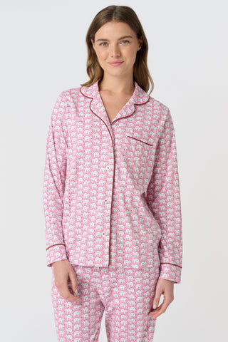 The Hathi Polo Pajamas feature white elephants outlined in red on a pink background, arranged in diagonal rows. Each stylized elephant has a red dot for an eye. Inspired by the Hathi print and made in Peru.