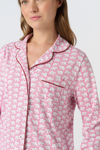 The Hathi Polo Pajamas feature white elephants outlined in red on a pink background, arranged in diagonal rows. Each stylized elephant has a red dot for an eye. Inspired by the Hathi print and made in Peru.