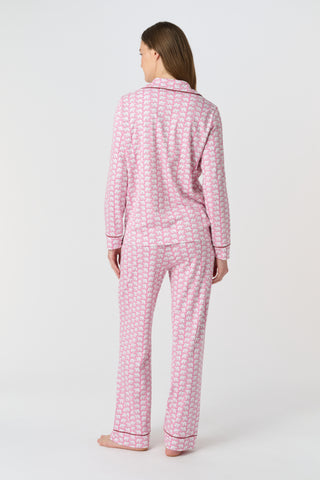 The Hathi Polo Pajamas feature white elephants outlined in red on a pink background, arranged in diagonal rows. Each stylized elephant has a red dot for an eye. Inspired by the Hathi print and made in Peru.