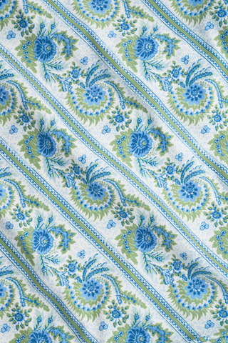 The Provencal Stripe Aurora One Piece by Roller Rabbit features diagonal blue and green floral stripes on white fabric, inspired by vintage swimsuits and enhanced with ultraviolet protection.