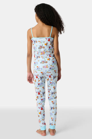 Young child with long brown hair stands barefoot, wearing the Roller Rabbit Kids Spain Monkey Noa Set—light blue Pima cotton loungewear with playful monkey prints and blue trim—against a plain white background.