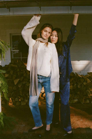 Roller Rabbit Dressing. Two women standing together in front of a house with a neutral background