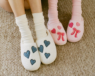 Roller Rabbit PJs. Two people wearing matching pajamas with heart designs on socks.