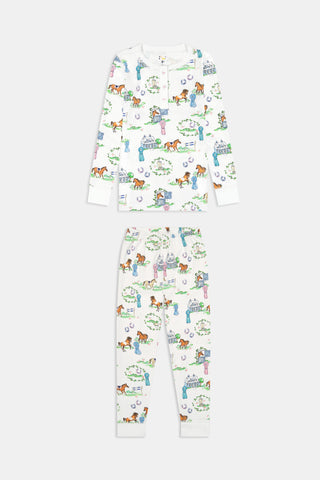 Introducing the Kids Saddle Up Pajamas by Roller Rabbit—a children’s pajama set crafted from premium Pima cotton, featuring a whimsical equestrian print of horses, castles, and greenery on a white background. This high-quality set includes a long-sleeve top and matching pants.