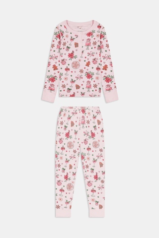 A child in a patterned Kids Seasons Soiree Juniper Pajamas two-piece set and rubber boots sits on a wooden sled and looks through binoculars.