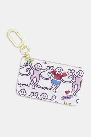 The Sigma Kappa Monkey Coin Pouch by Roller Rabbit is a compact water-resistant cotton canvas pouch featuring playful cartoon monkeys—one in a red sweater—holding hands. It has a gold clip for easy attachment and is adorned with the words “Sigma Kappa” and “BID DAY.”.
