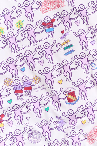 The Sigma Kappa Monkey Polo Pajamas by Roller Rabbit are a short-sleeve pajama set featuring matching shorts with a white background and colorful cartoon character pattern. Designed for comfort, they include a front button placket and an elastic waistband.