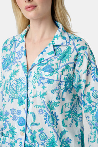 The Amanda Loungewear pajama set features white cotton fabric adorned with blue and turquoise floral and botanical patterns, adding a charming, intricate touch to women’s sleepwear.